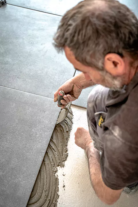 ouvrier en train de poser du carrelage