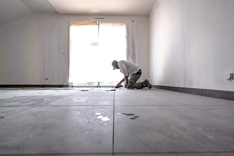 ouvrier en train de manipuler un carton avec des carreaux de carrelage